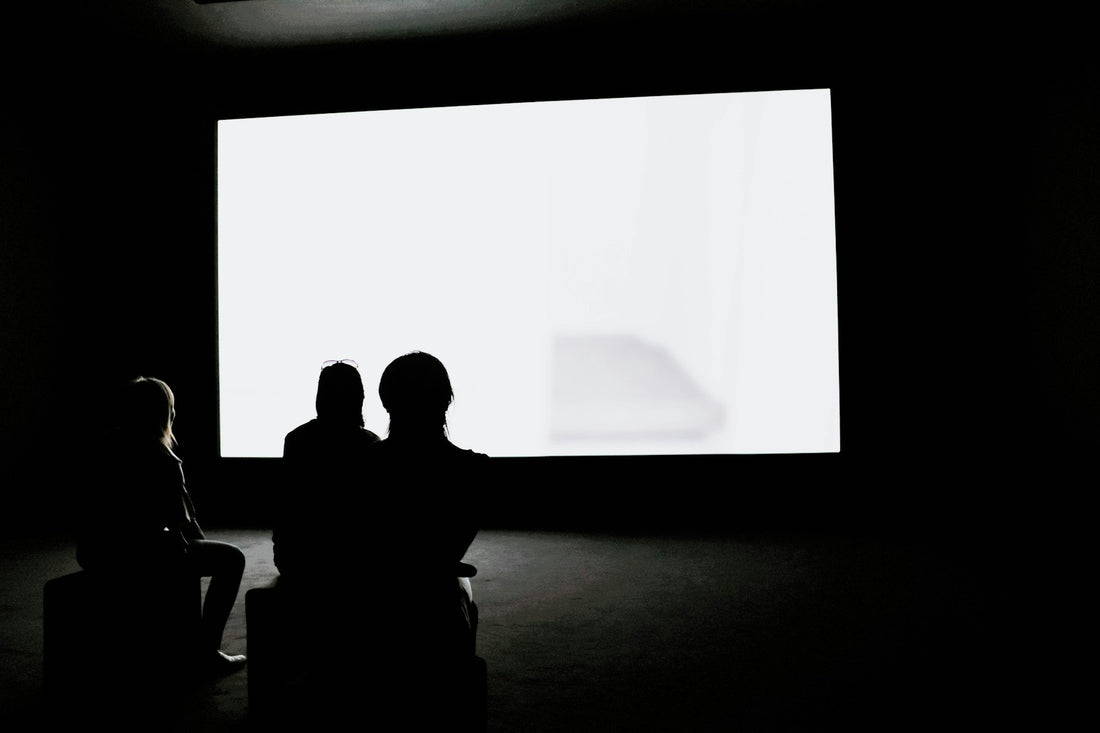 Spectateurs devant un grand écran de projection