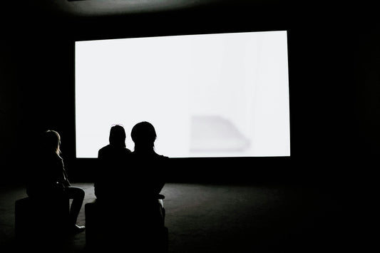 Spectateurs devant un grand écran de projection