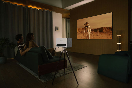 Un vidéoprojecteur sur trépied projette un film sur un mur dans une pièce sombre