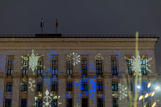 Façade d'un bâtiment illuminée de flocons projetés de nuit